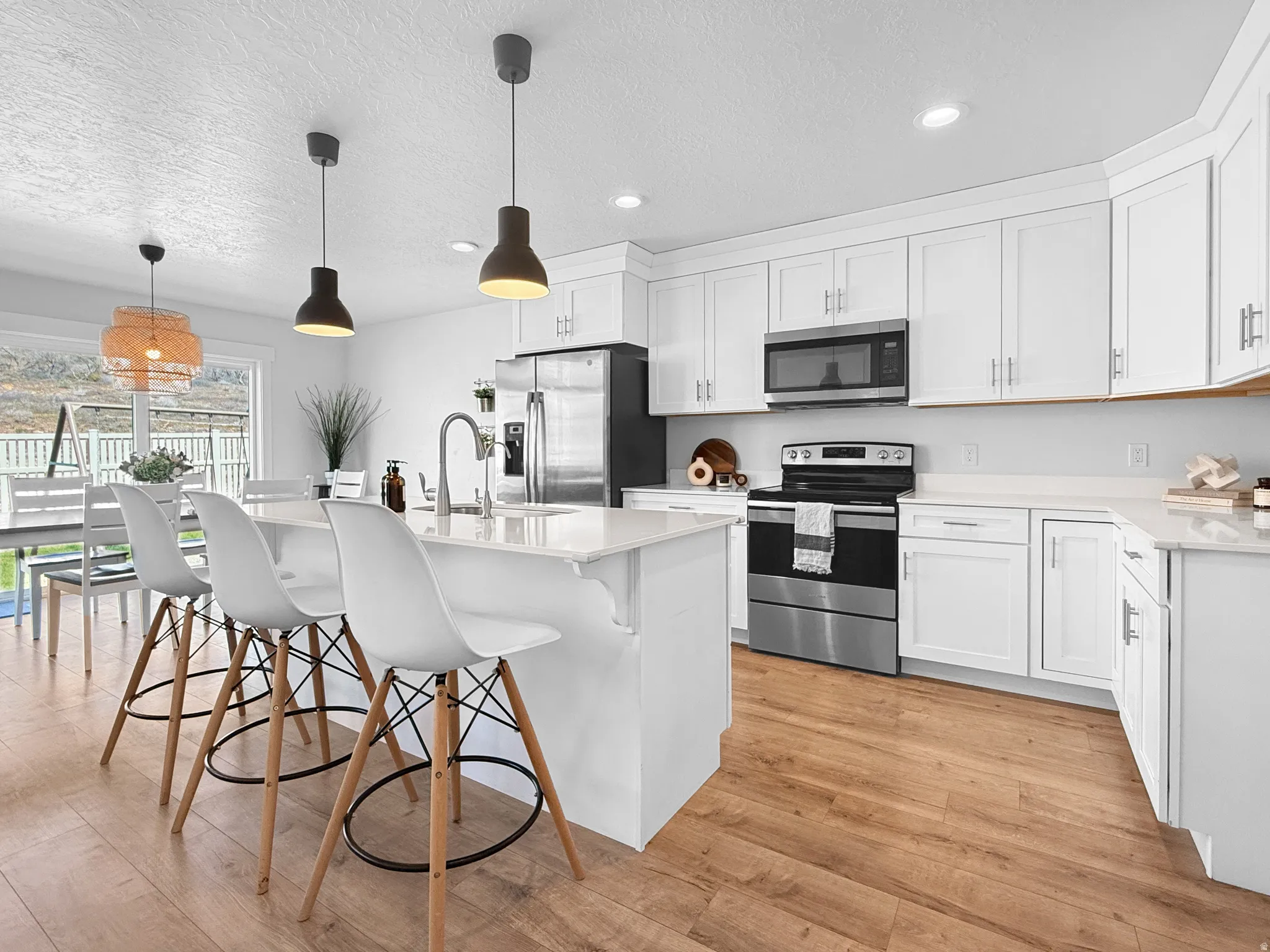 Contemporary kitchen with white cabinetry and wood-finish flooring