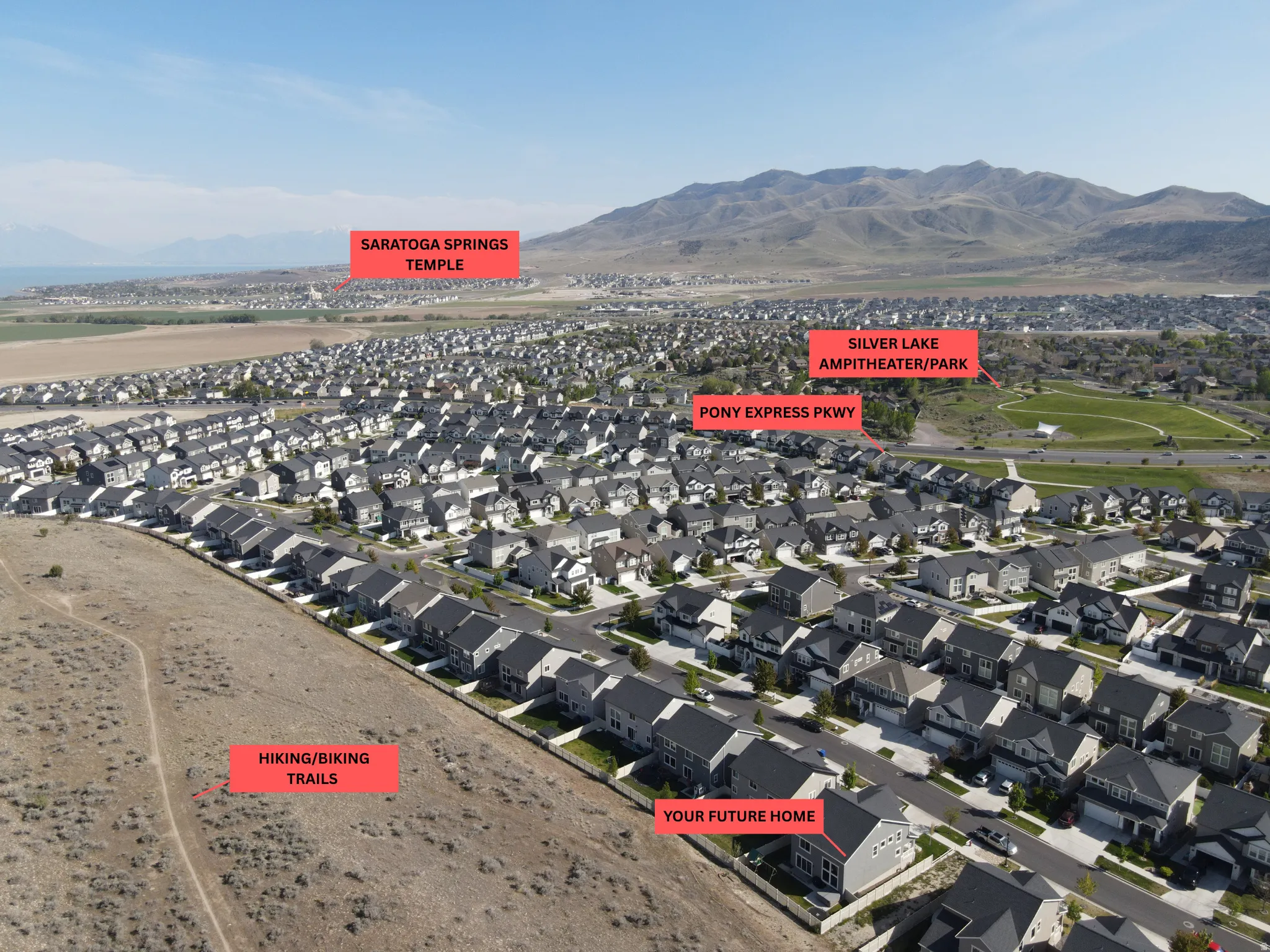 Aerial perspective showcasing a residential community with distant mountains and a body of water