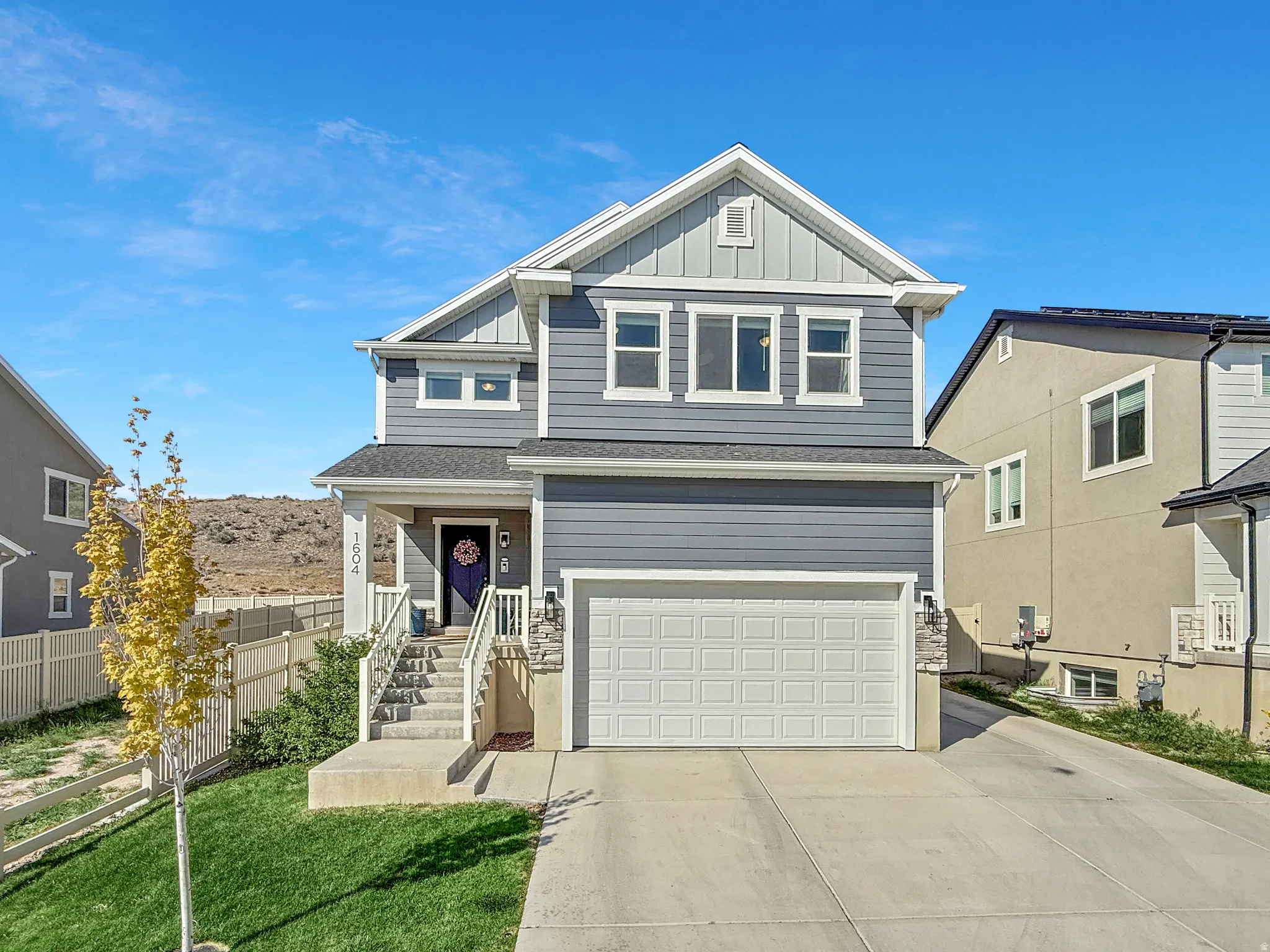 Two-story residence featuring blue siding with white trim, a gabled roofline, and an attached two-car garage