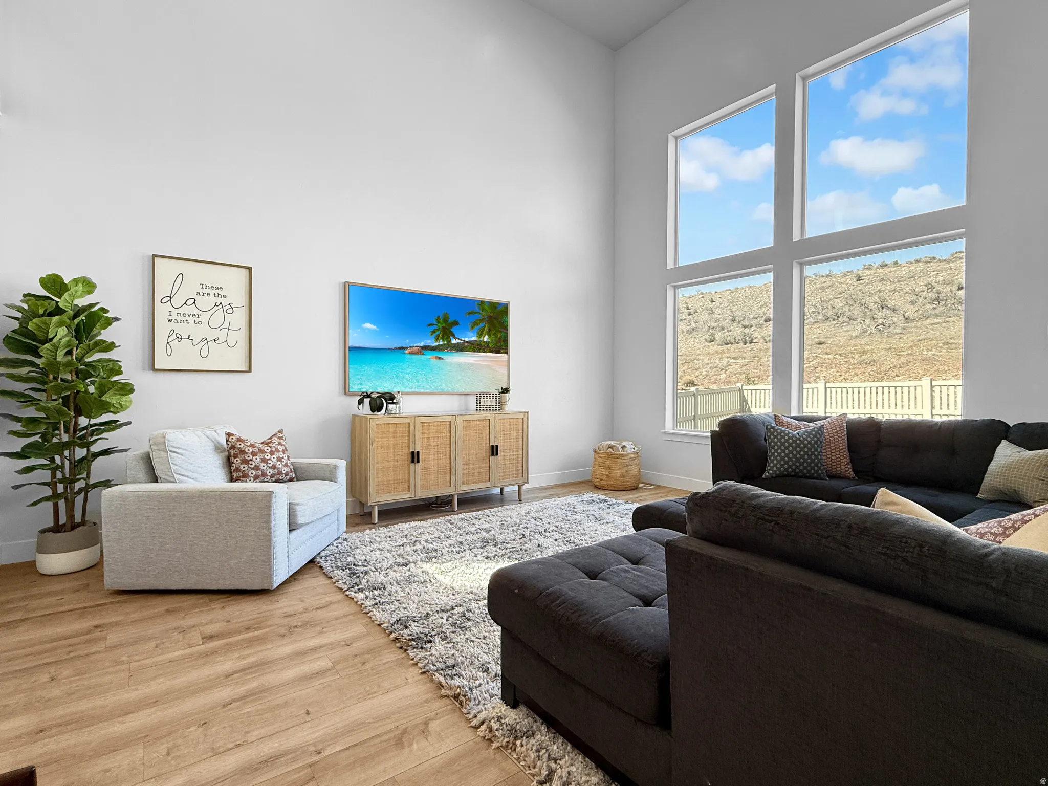Bright living area featuring soaring ceilings and oversized picture windows