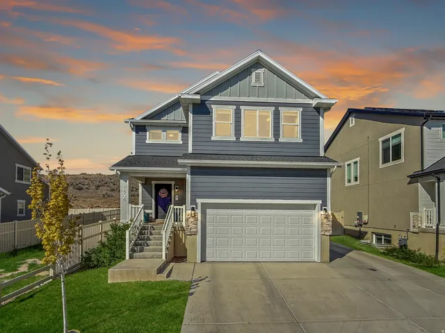 Two-story residence featuring a gray exterior with white trim, an attached two-car garage, a covered front porch, concrete steps, and a landscaped front yard