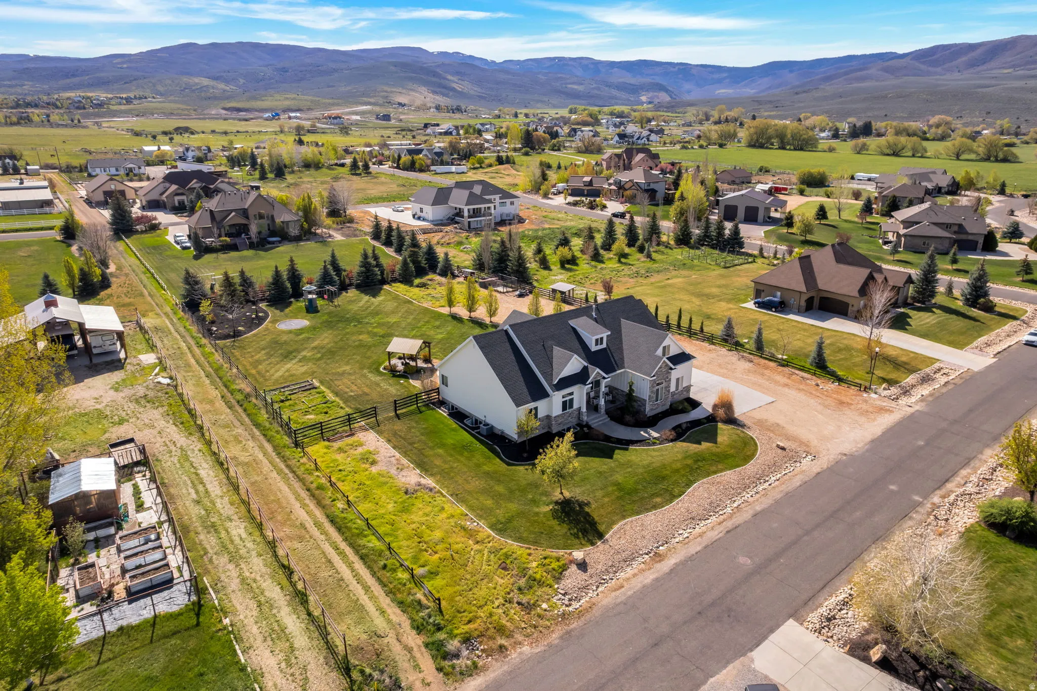 Expansive property featuring a large residence with a multi-gabled roof and stone facade accents