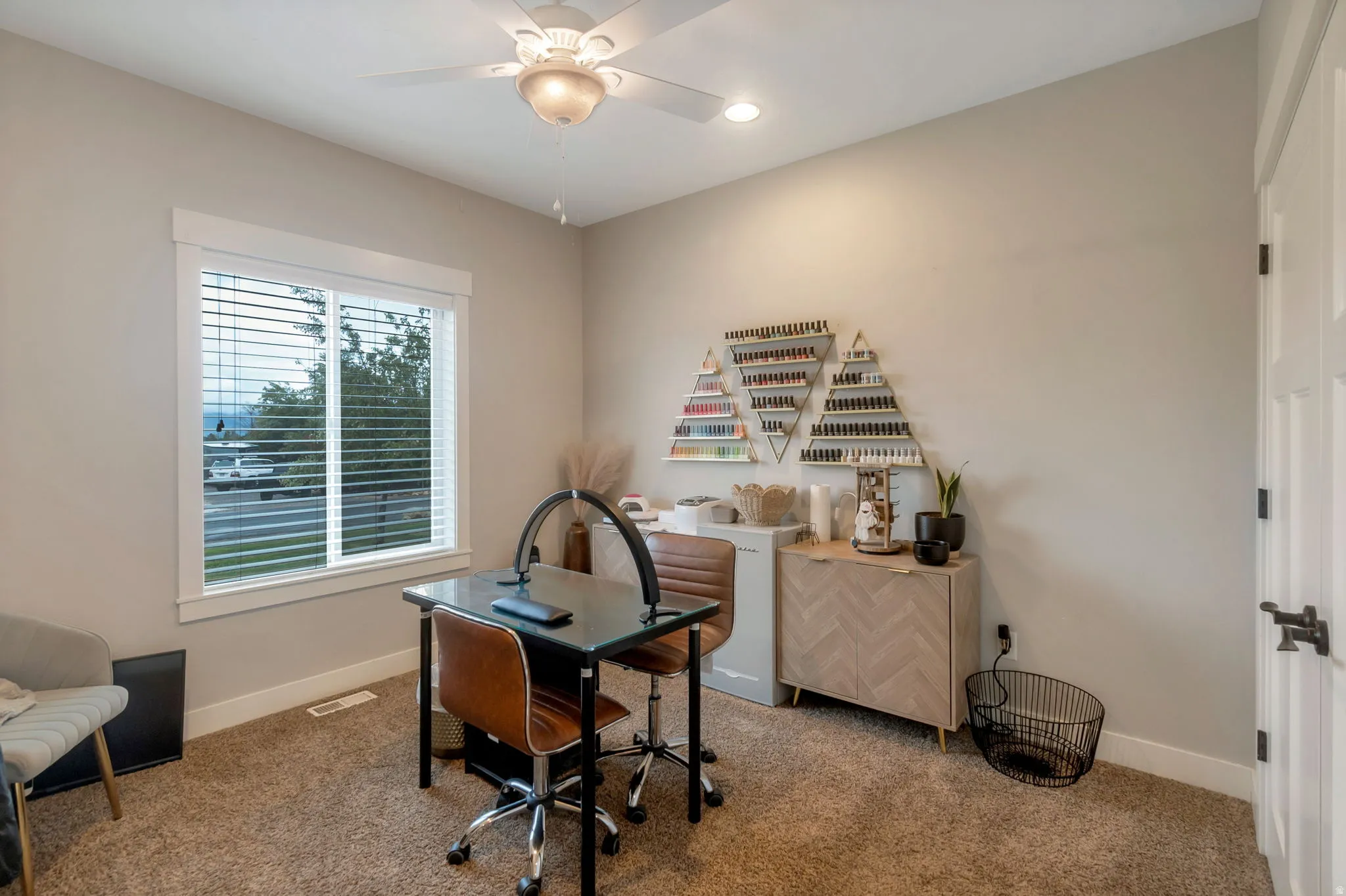 Neutral wall paint, textured carpet flooring, and a large window with white trim
