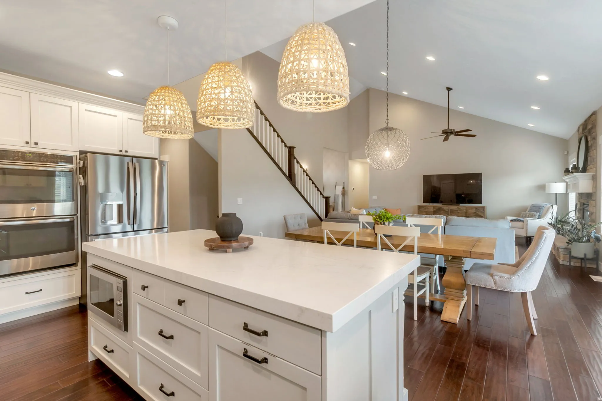 Kitchen island with white countertop, integrated microwave, and pendant lighting