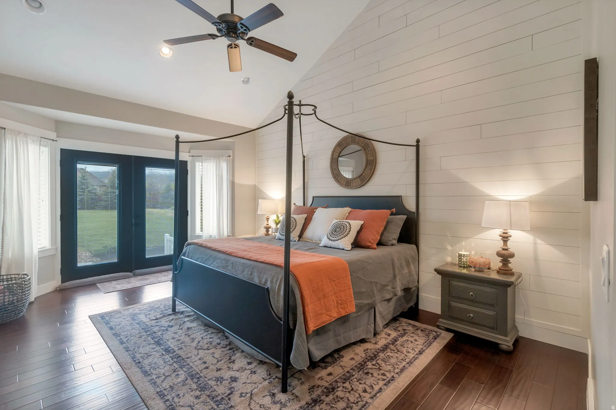 Vaulted ceiling bedroom featuring wood-finish flooring and a ceiling fan