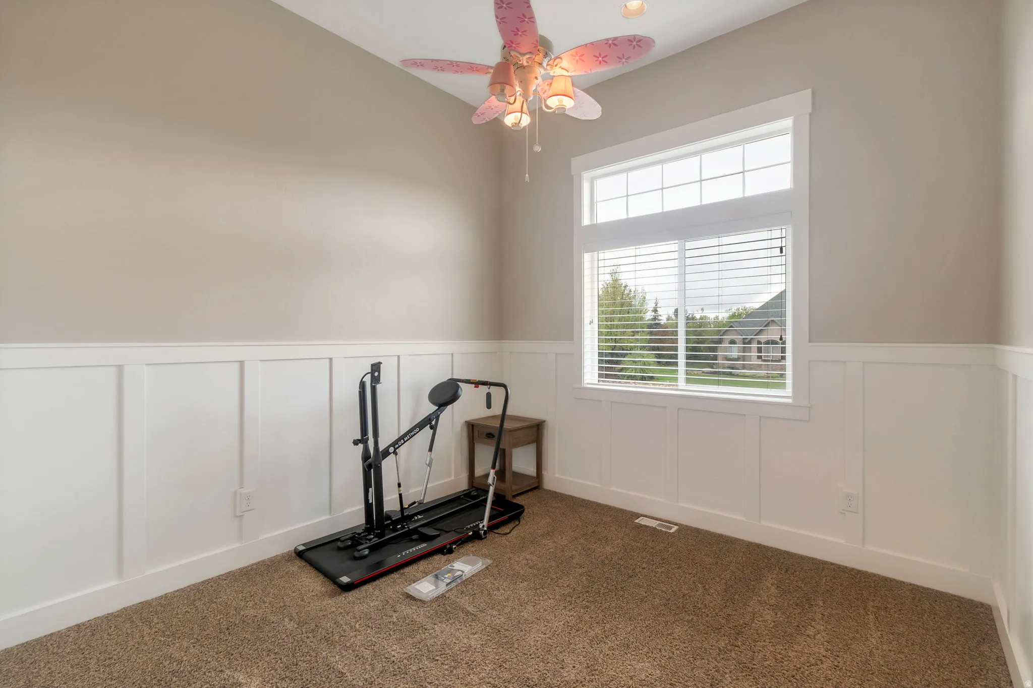 Room featuring board and batten wainscoting, neutral tone walls, and vaulted ceilings