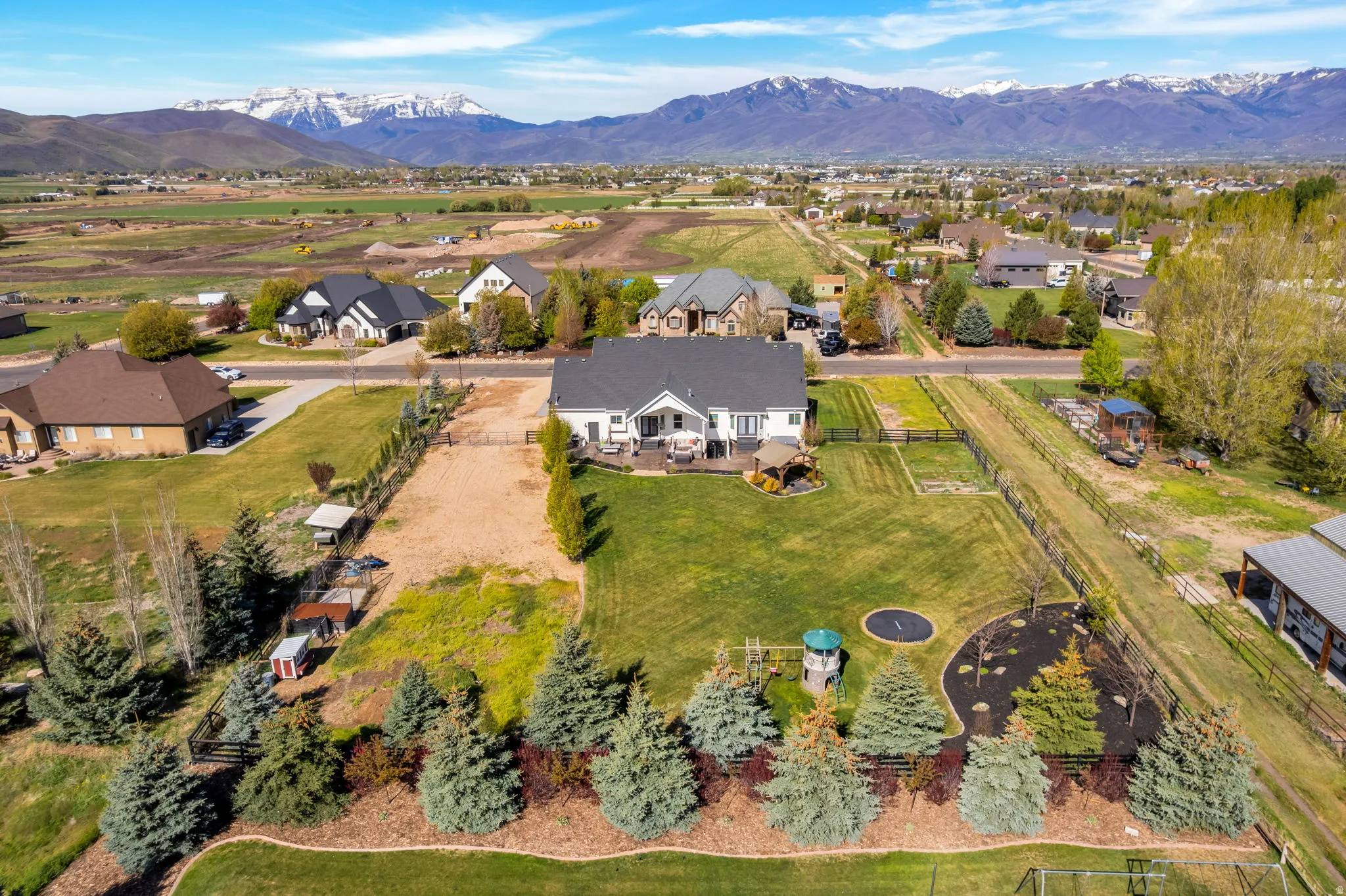 Expansive property featuring a large manicured lawn, established landscaping, and a substantial rear patio