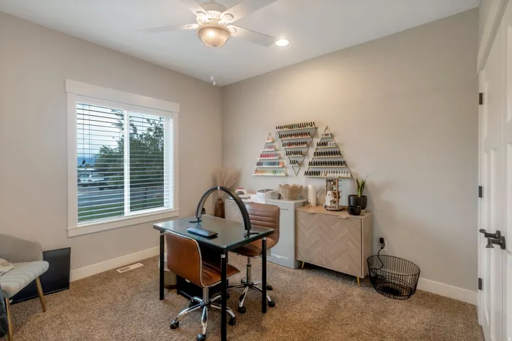 Neutral wall paint, textured carpet flooring, and a large window with white trim