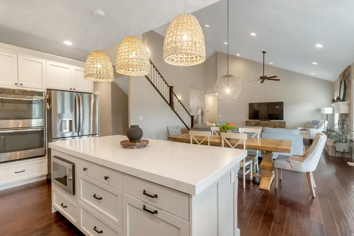 Kitchen island with white countertop, integrated microwave, and pendant lighting