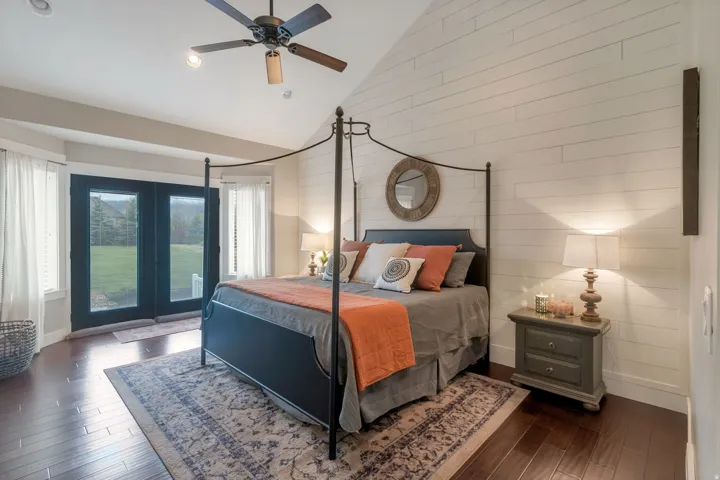 Vaulted ceiling bedroom featuring wood-finish flooring and a ceiling fan