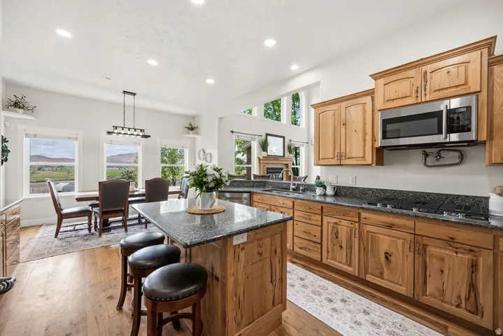 Kitchen featuring wood-finish cabinetry, dark granite countertops, and stainless steel appliances
