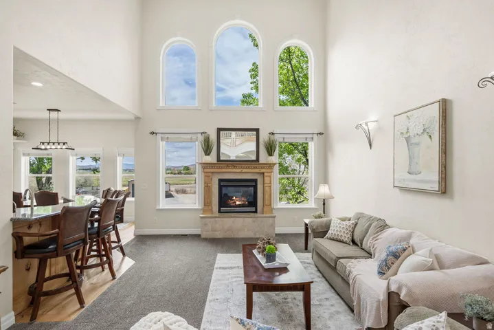 Living room featuring a vaulted ceiling and a stone-clad fireplace with a wood mantle