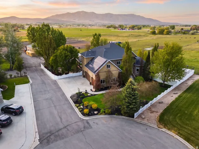 Expansive property with a large residence, featuring a dark shingle roof and solar panels