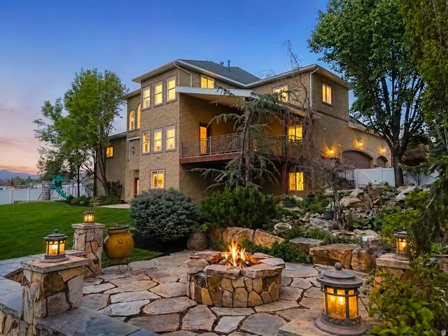 Expansive rear patio featuring flagstone paving and a stone fire pit