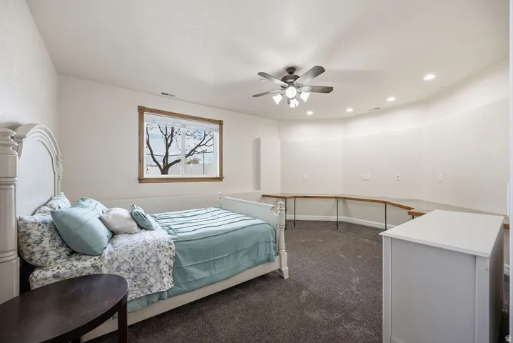 Spacious interior room with neutral wall tones and dark carpeting