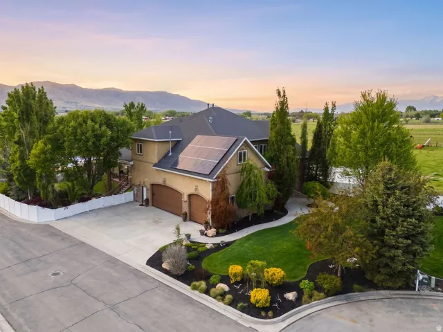 Stucco exterior with arched garage doors and solar panels