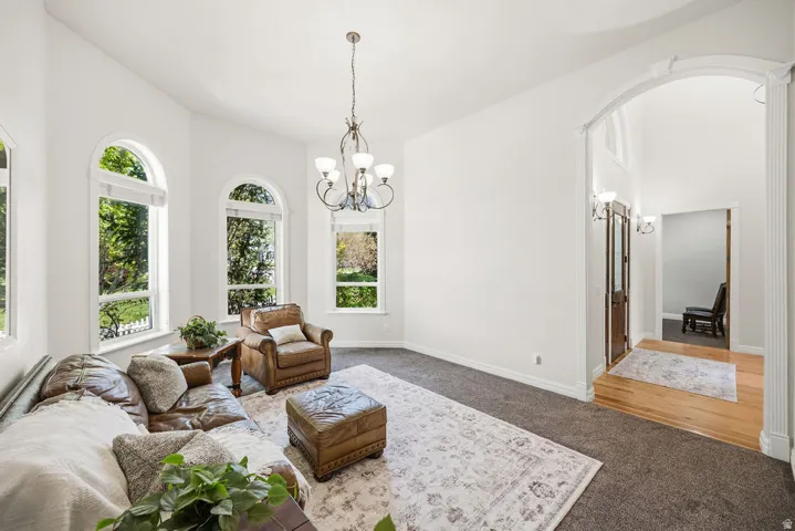 Vaulted ceilings complement arched windows, providing abundant natural light could be rec room or living room, right off front entry