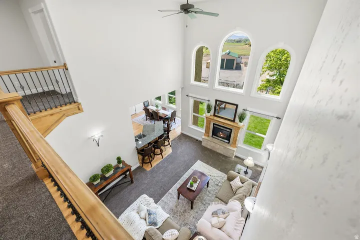 Two-story living area with high ceilings, three arched windows, and a built-in fireplace featuring a stone surround