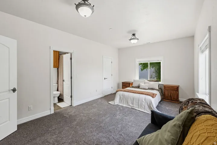 Spacious bedroom featuring neutral carpeting, white trim, and two semi-flush ceiling light fixtures