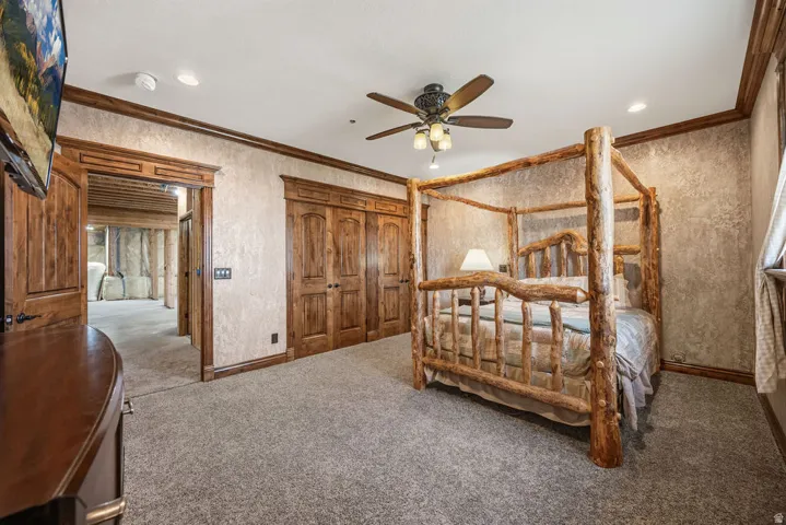 Carpeted room featuring wood-finish trim, textured walls, a ceiling fan with integrated lighting, and recessed lighting