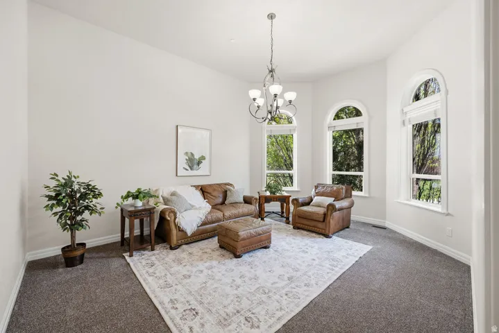 Bright interior space featuring three arched windows, a chandelier, and neutral wall paint