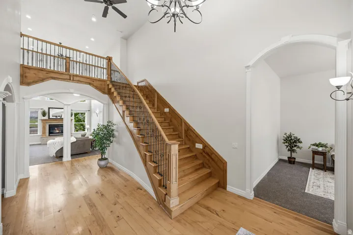 Grand entryway featuring a sweeping staircase with wood treads and wrought iron balusters