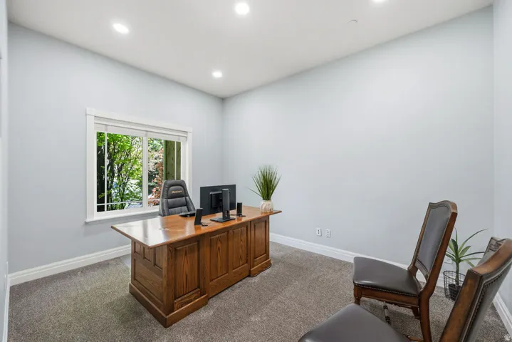 Carpeted room with a large window featuring white trim