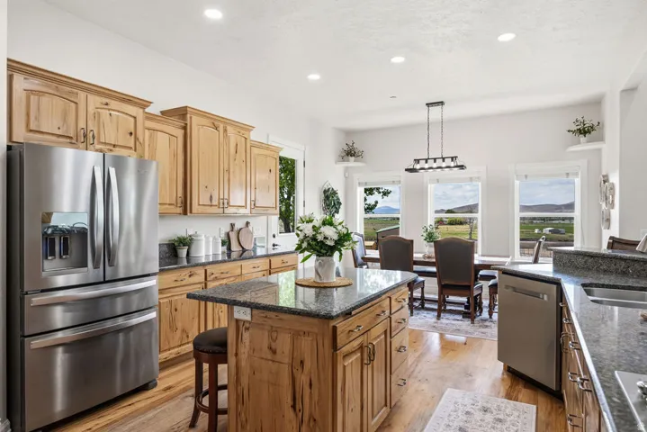 Kitchen featuring wood-finish cabinetry, stainless steel appliances, and granite countertops