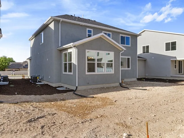 Two-story residence featuring a gray stucco exterior and white window trim