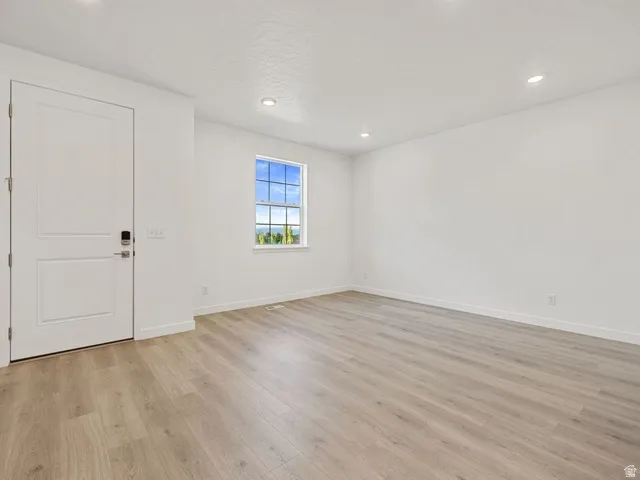 Room featuring wood-finish flooring, recessed lighting, and a multi-pane window