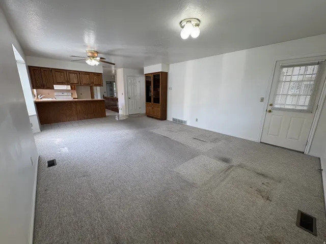 Open-concept room featuring light-colored carpeting and white wall finishes