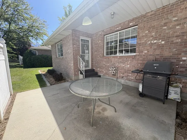 Brick exterior featuring a covered patio with a concrete surface