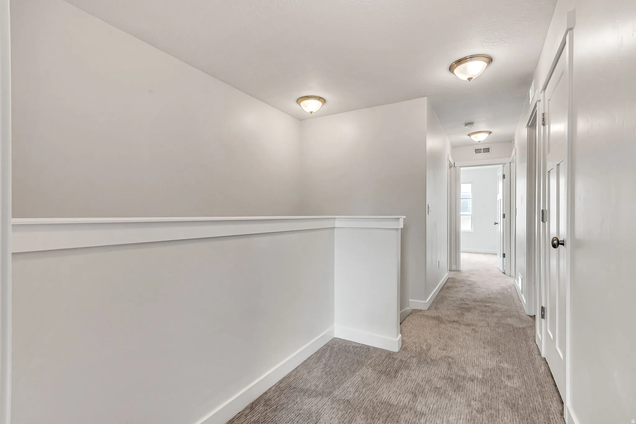 Hallway featuring neutral carpet flooring, recessed lighting, white walls, and white trim