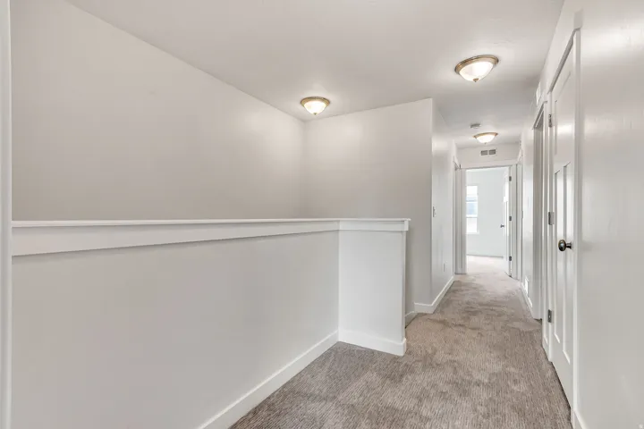 Hallway featuring neutral carpet flooring, recessed lighting, white walls, and white trim