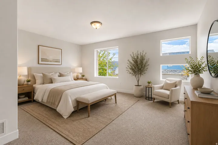 Bright bedroom featuring multiple windows, neutral tone carpeting, and a flush mount ceiling light