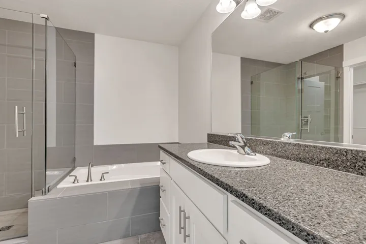 Bathroom featuring a vanity with a speckled countertop, undermount sink, and chrome faucet
