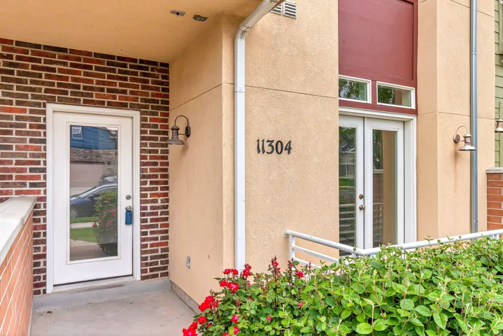 Stucco and brick exterior with glass-paneled entry door and French doors