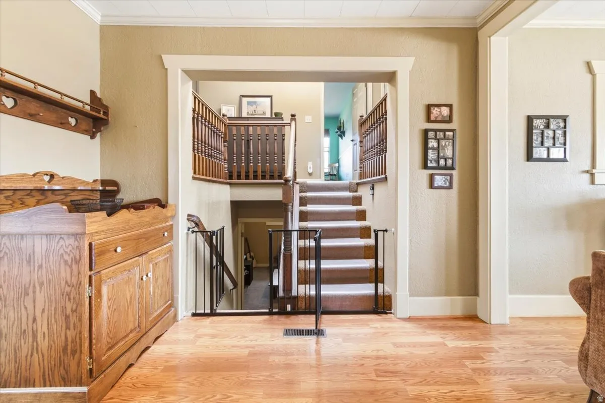 Two-story staircase featuring wood railing and carpeted steps