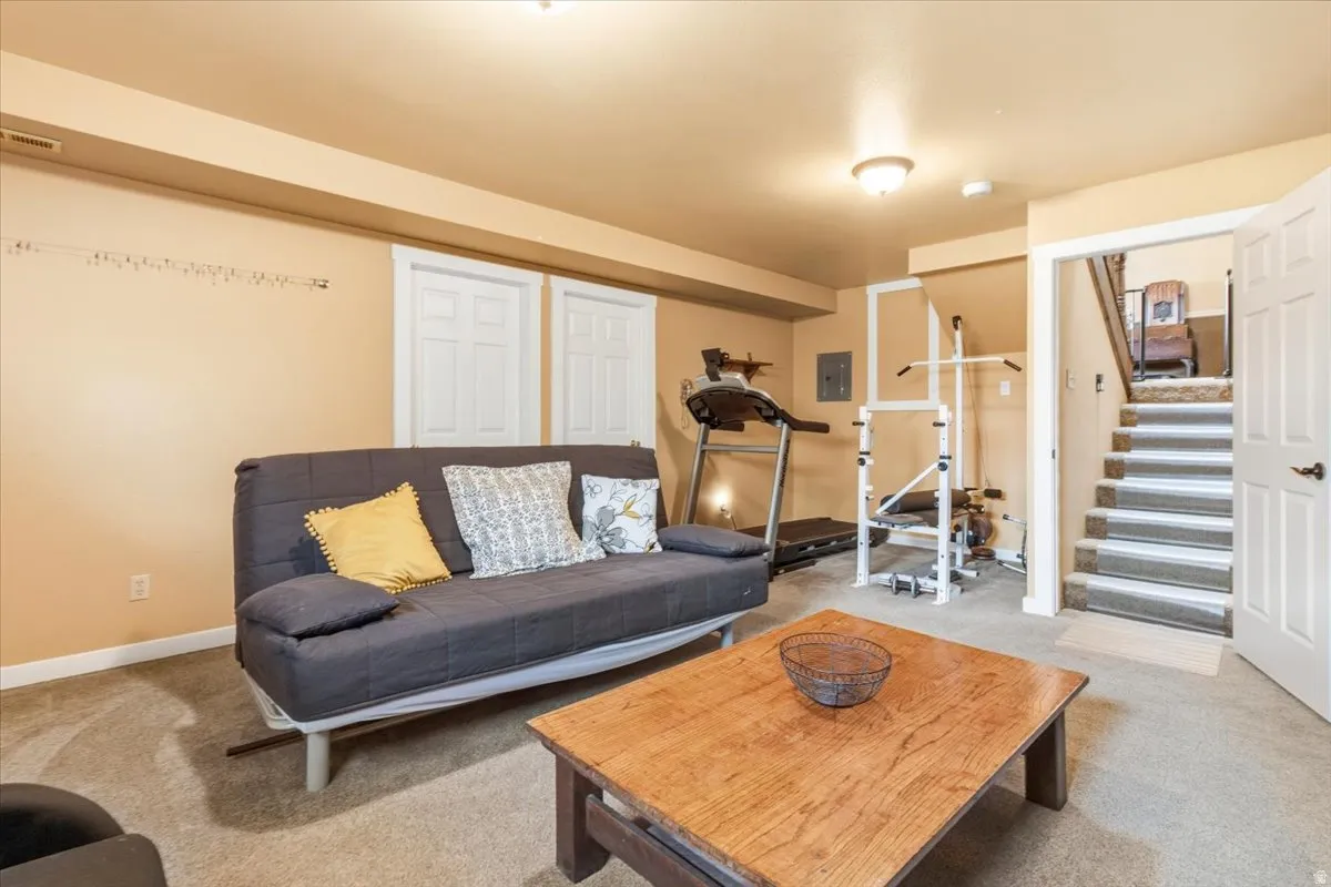 Carpeted lower-level room featuring cream-colored walls, white trim, and a recessed ceiling light