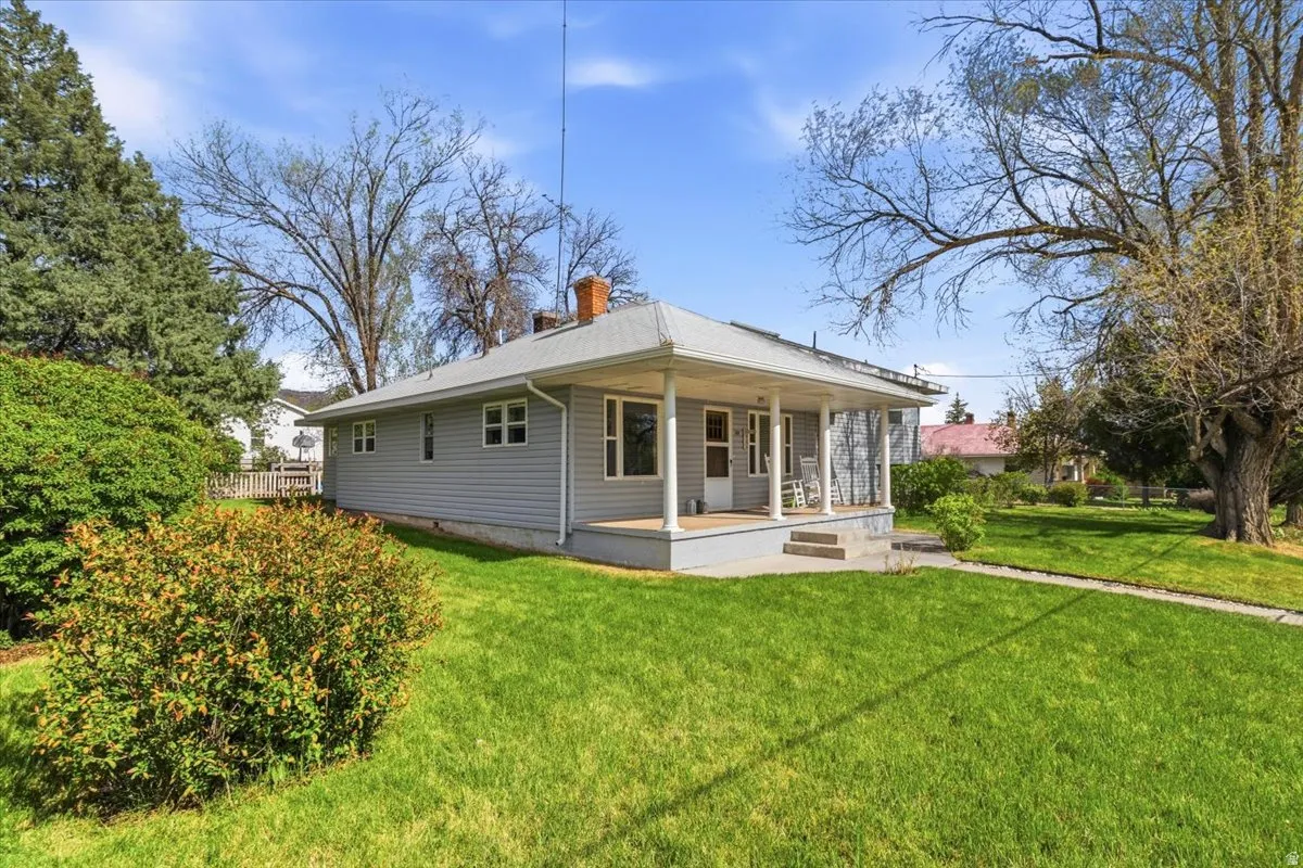 Single-story residence featuring light gray siding and a covered front porch