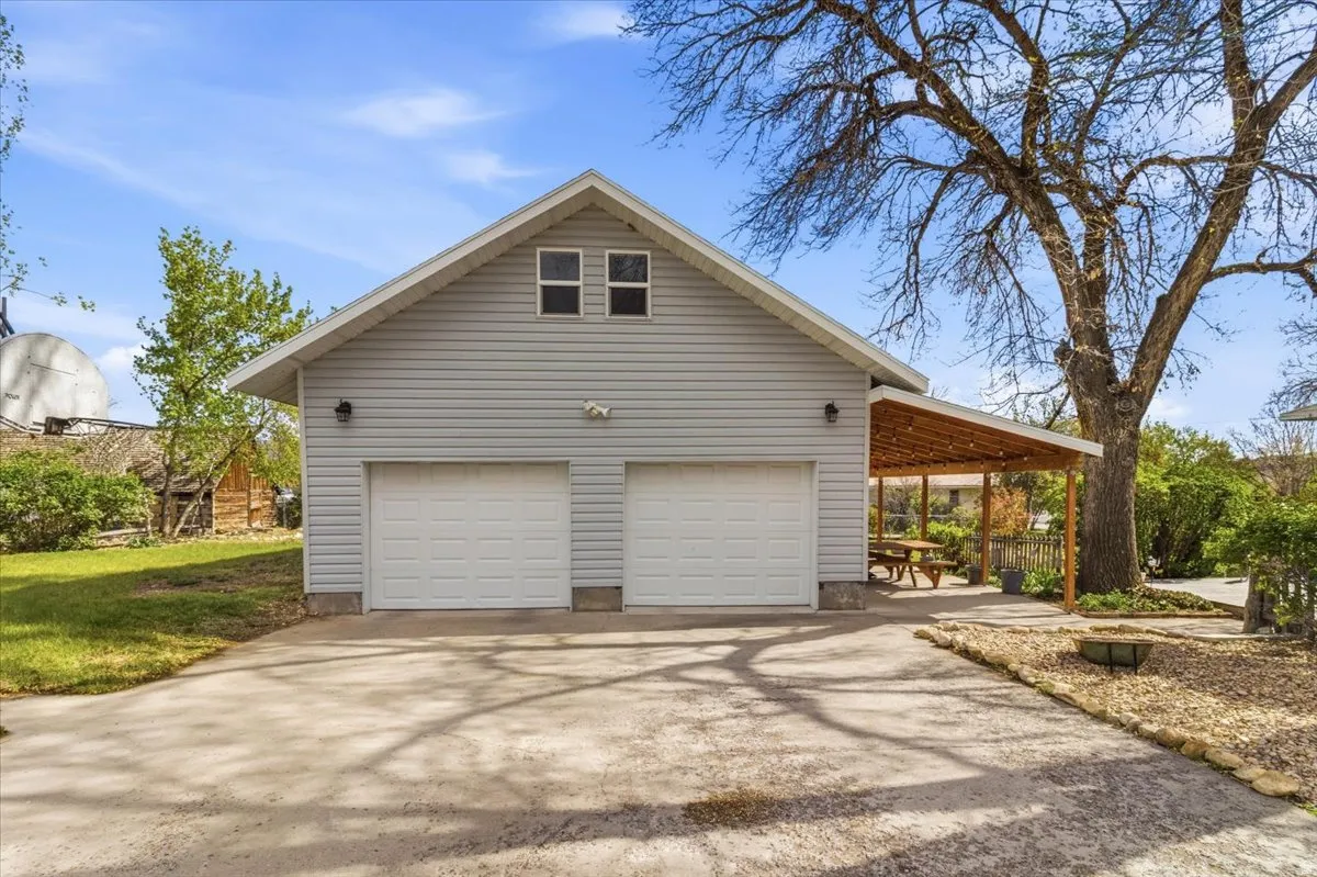 Two-car garage with light gray siding and upper windows