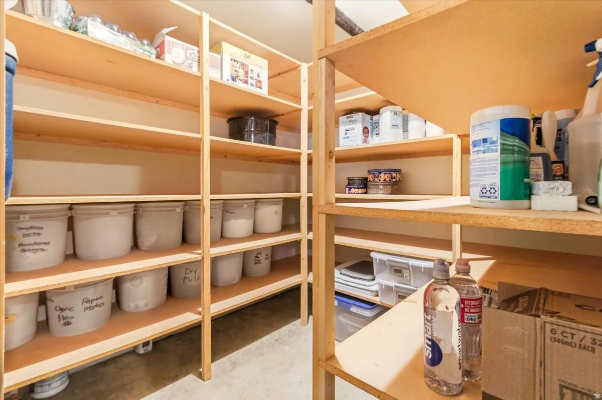 Pantry with multiple levels of light wood-finish shelving