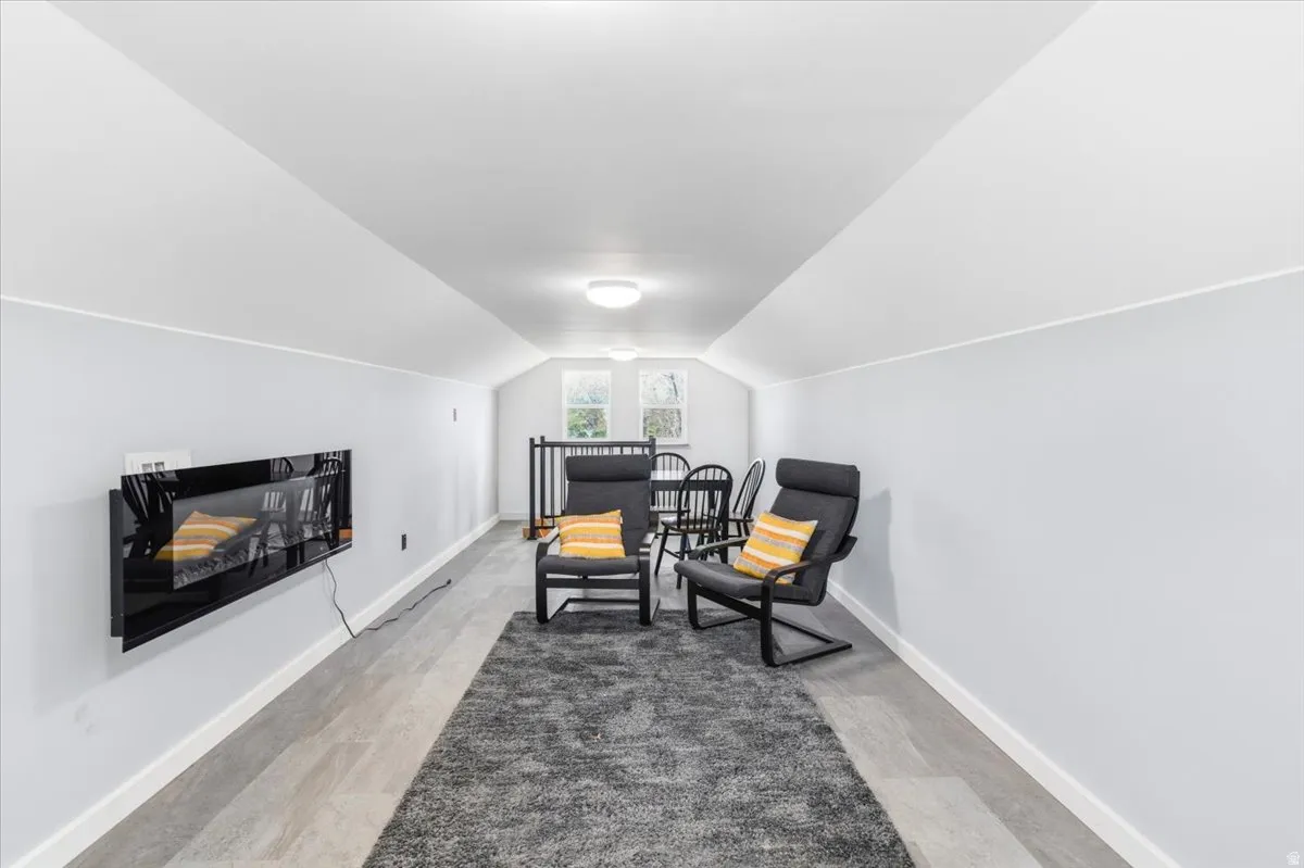Finished upper-level area featuring light-toned walls, wood-finish flooring, and recessed lighting