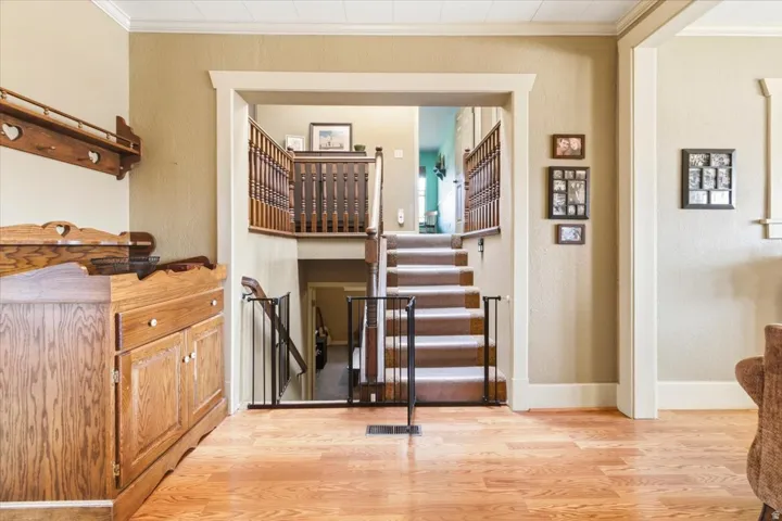 Two-story staircase featuring wood railing and carpeted steps