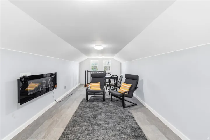 Finished upper-level area featuring light-toned walls, wood-finish flooring, and recessed lighting