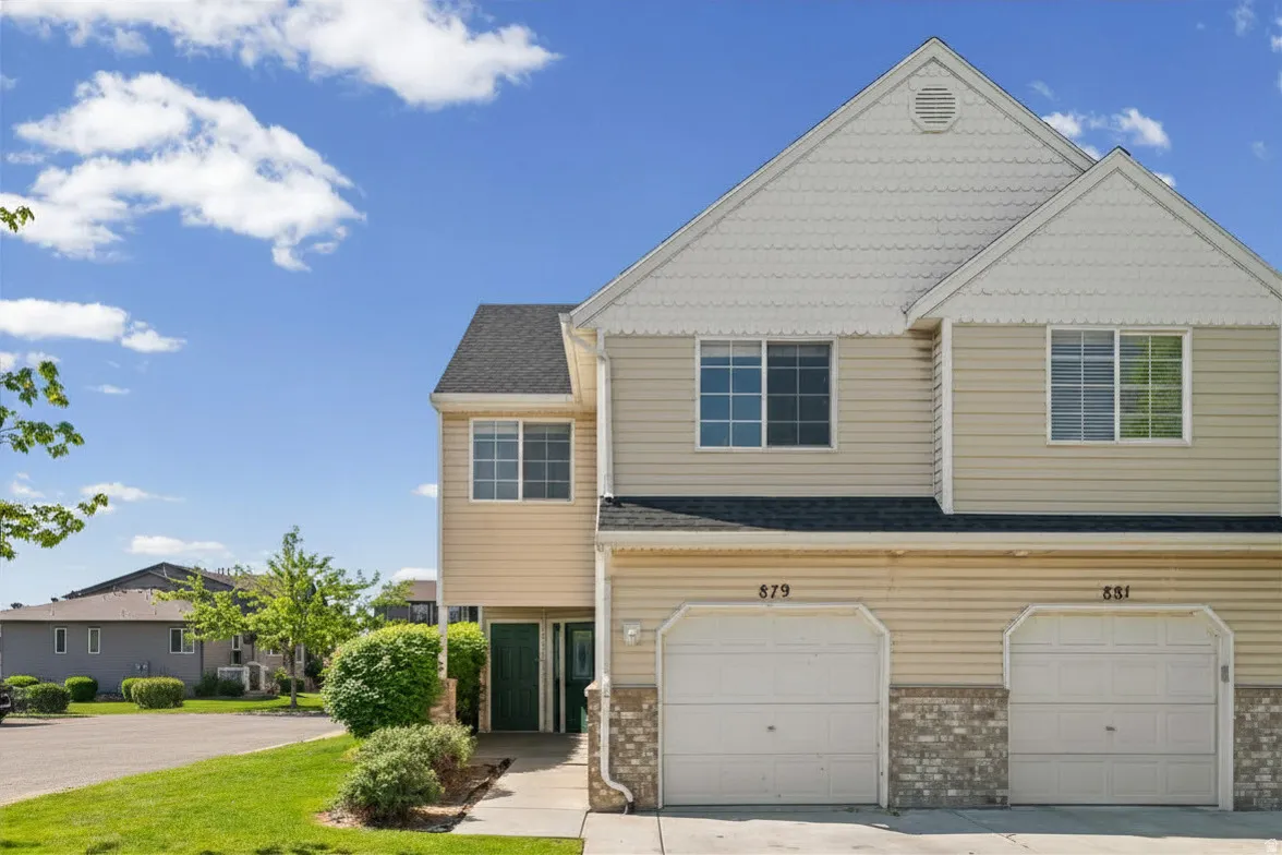 Condo exterior featuring light beige siding and white scalloped shingles