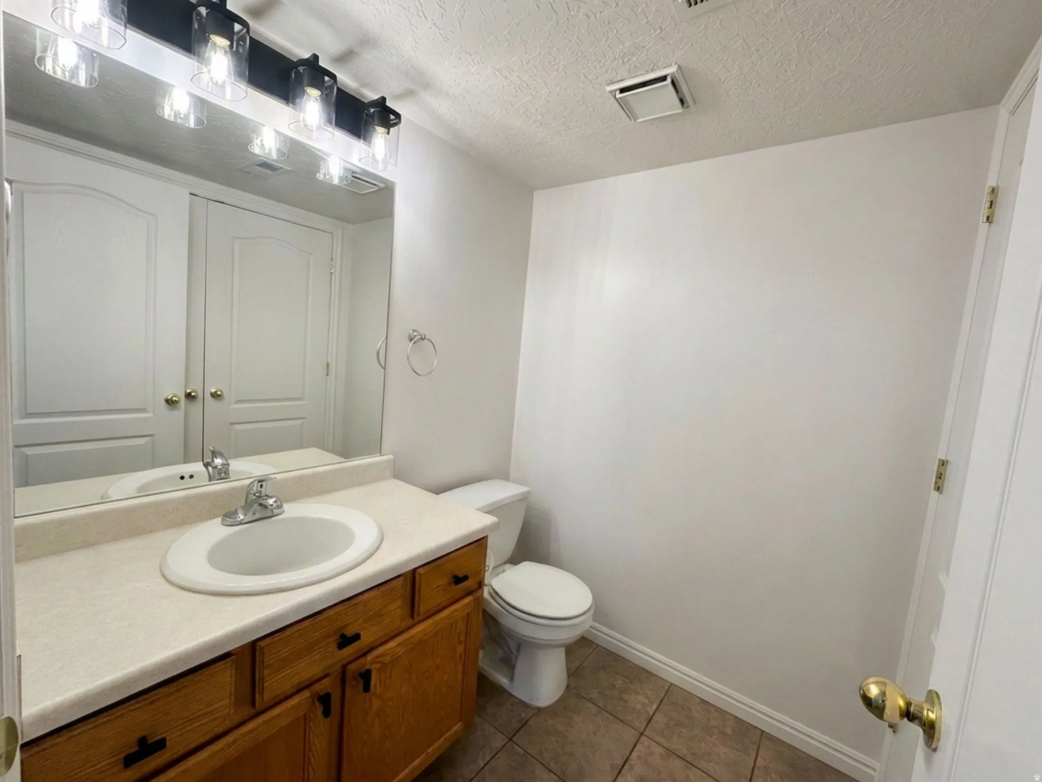 Half Bathroom with vanity and a single basin sink, laminate countertop, and wood-finish cabinetry