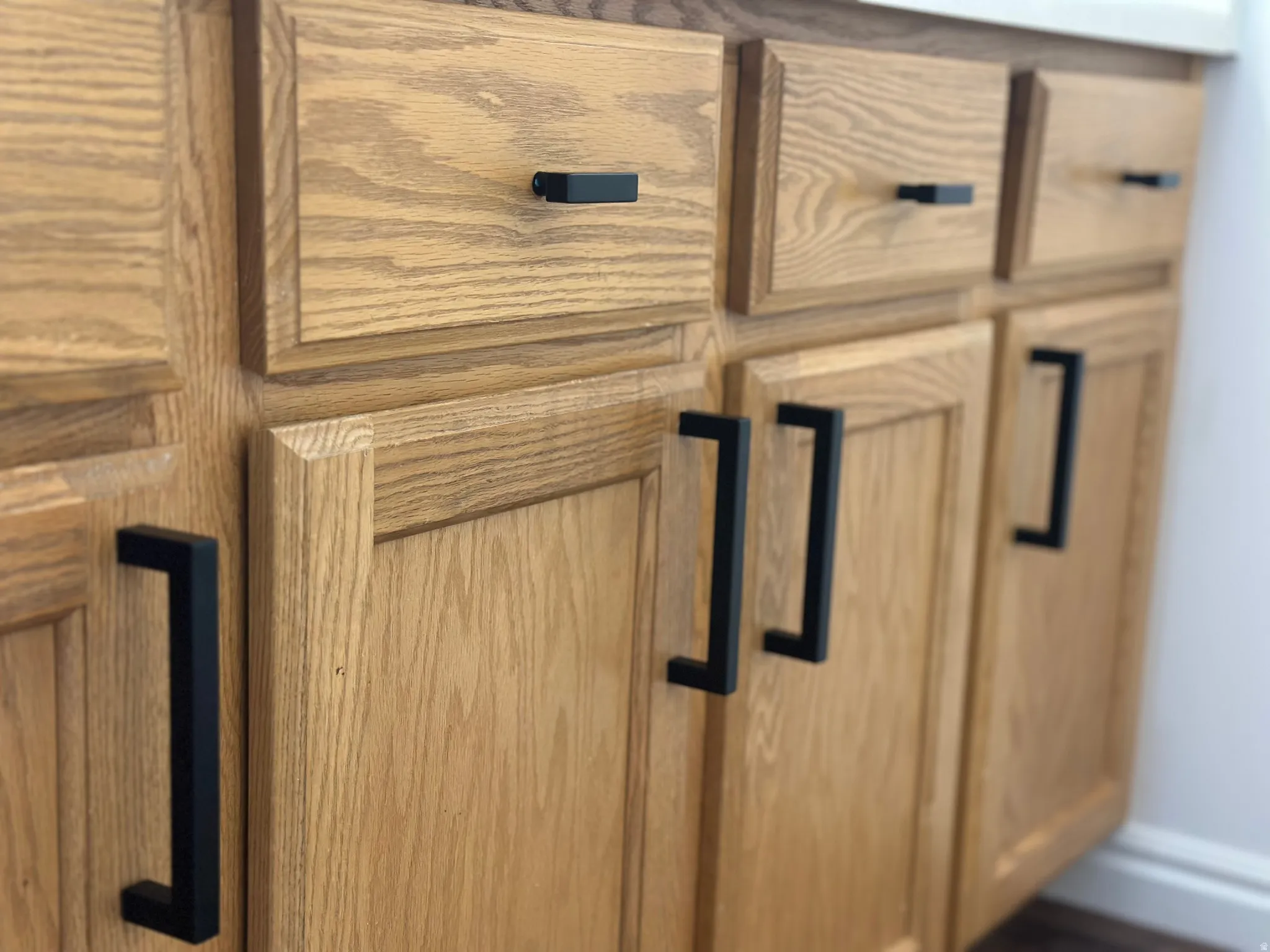 Wood-finish cabinetry with contemporary matte black hardware