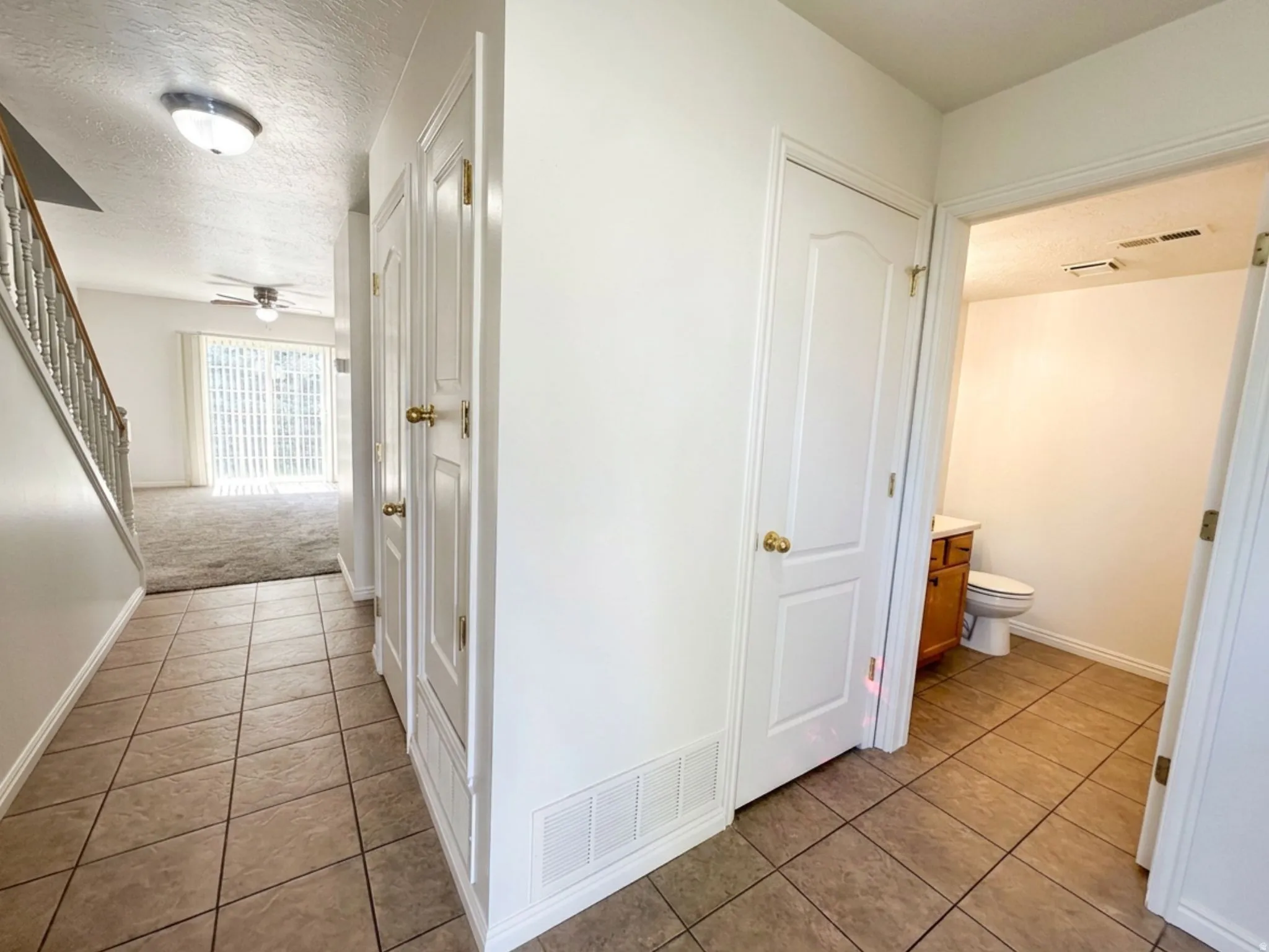 Tiled entry with staircase, white paneled doors, and ceiling-mounted light fixture