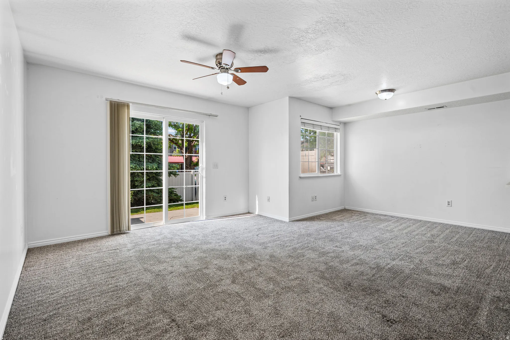 Spacious room featuring neutral carpeting and white painted walls